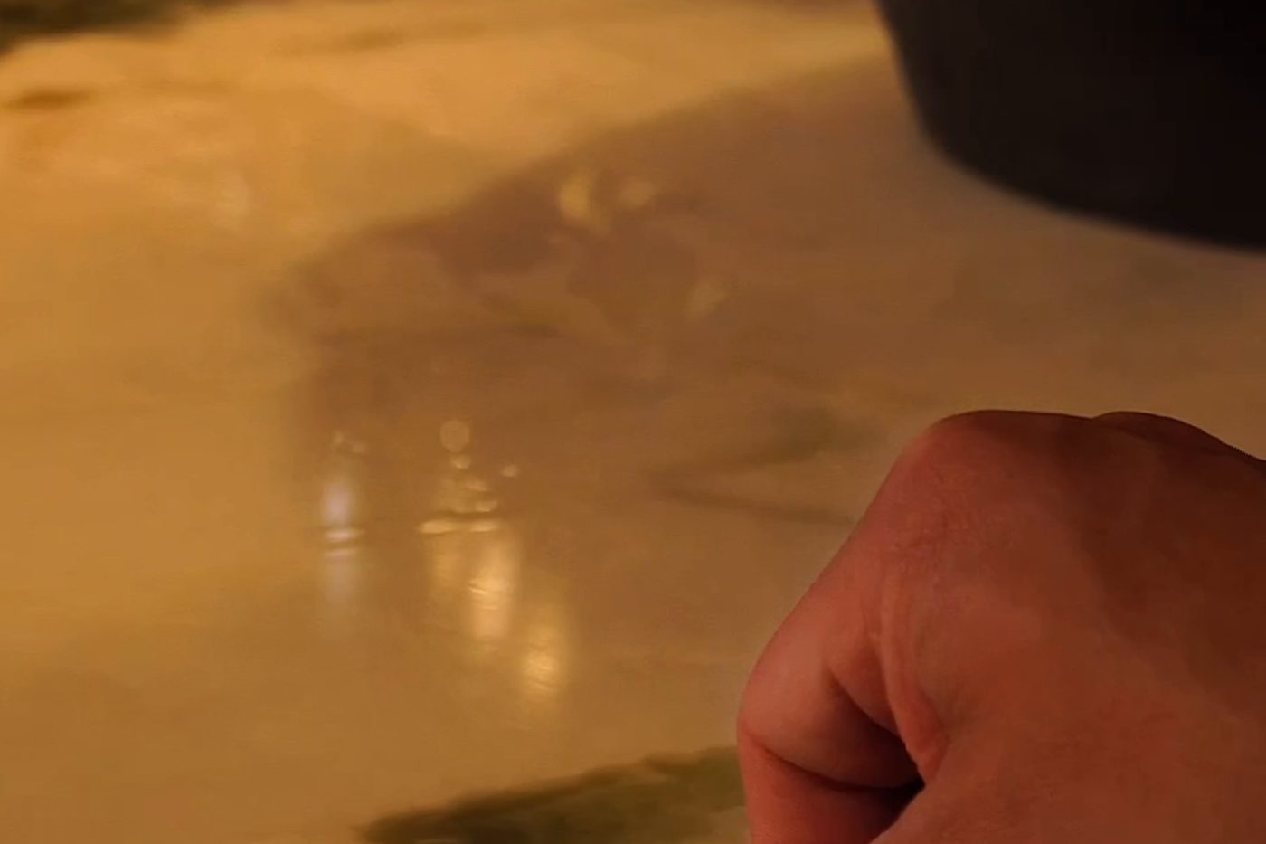 Blade trimming the protective film along the edge of a stone bar top