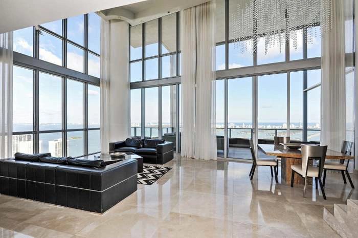 Waterfront residence living area with a full wall of glass facing the water